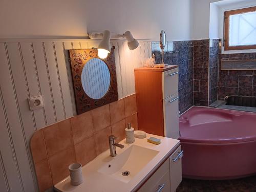 La salle de bains est pourvue d'un lavabo et d'une baignoire rose. dans l'établissement Les glycines, au Cannet-des-Maures