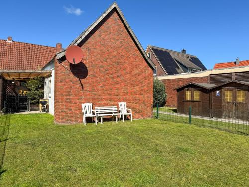 a house with a table and chairs in the yard at Großer Hookie in Hooksiel