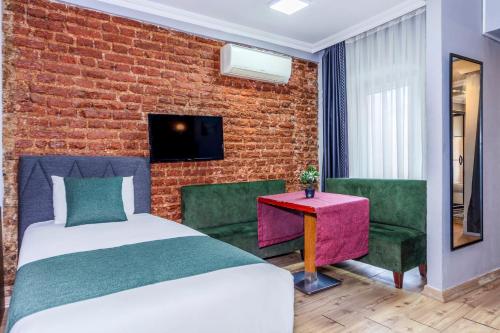 En eller flere senge i et værelse på La Pera Suites