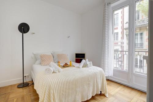 une chambre blanche avec un lit et une grande fenêtre dans l'établissement 5018 Suite Murillo - Nice apartment Champs-Élysées, à Paris
