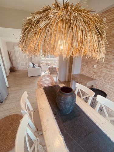 a dining room with a table with a vase on it at KIPOS-SS residences in Dassia