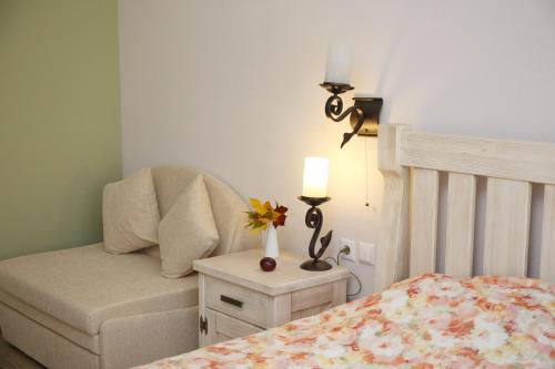 a bedroom with a bed and a chair and a lamp at Agrousadba Krasnoye in Kosʼye