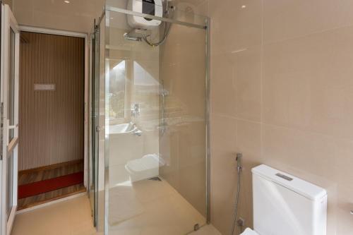 a bathroom with a shower and a toilet and a sink at Hotel Grand Turf By GSP in Nuwara Eliya