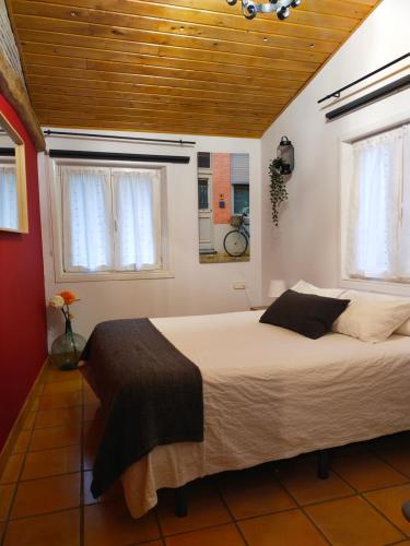 a bedroom with a large bed and two windows at ANTZOMENDI in Mutriku