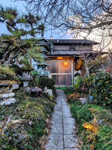 a house with a pathway leading to the front of it at 1棟貸切で家族仲間と焚火バーベキューを楽しめる古民家NanasawaBasshouse in Atsugi