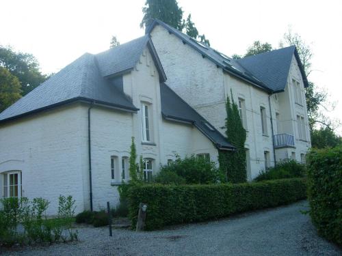 ein großes weißes Haus mit schwarzem Dach in der Unterkunft Quaint Holiday Home in Chimay with Garden in Plagneau