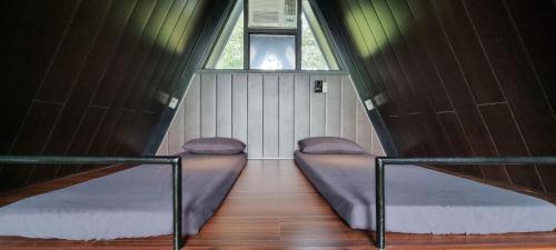 two beds in a small room with a window at My Cabin by One Selah in Bustos