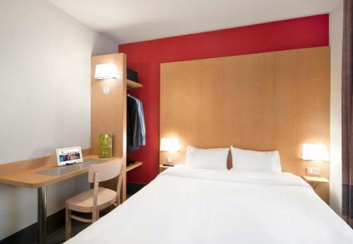 a hotel room with a large bed and a desk at B&B HOTEL Grenoble Centre Alpexpo in Grenoble