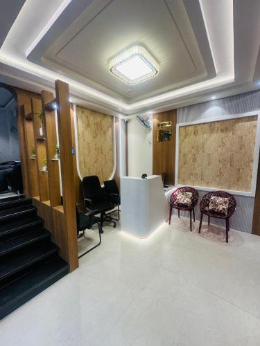 a waiting room with chairs and a table and stairs at hotel deep palace in Varanasi