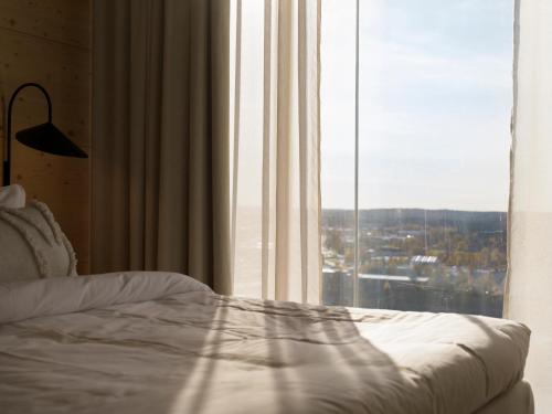 a bedroom with a bed and a large window at The Wood Hotel by Elite in Skellefteå