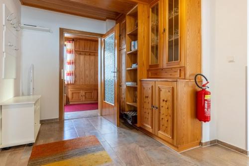 a kitchen with wooden cabinets and a red fire extinguisher at RosHof Apartments in Spital am Semmering