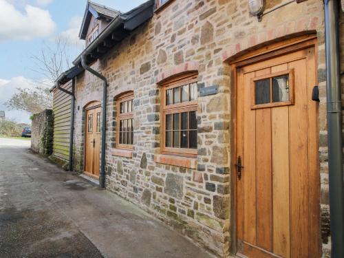 a stone building with wooden doors on a street at The Hideaway in Bishops Castle