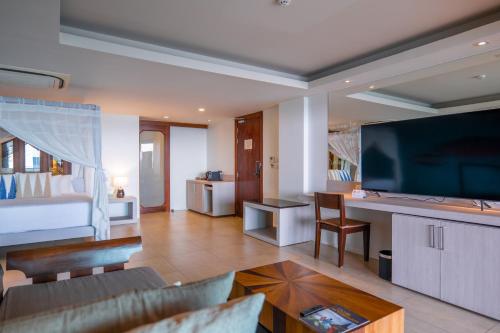 a living room with a couch and a television at Zenmaya Oceanfront Phuket, Trademark Collection by Wyndham in Patong Beach