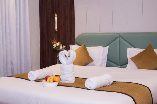 a hotel room with a bed with towels and fruit at Hotel Abshar in Pahalgām