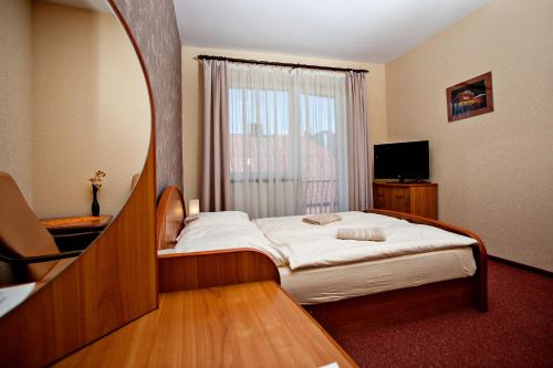 a hotel room with a bed and a window at Villa Centrum Młodości in Augustów