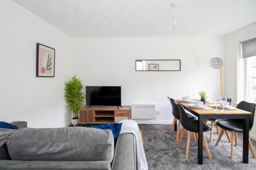 a living room with a couch and a table at Greenside Getaway in Newarthill