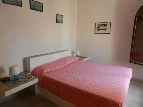 a bedroom with a bed with a pink comforter at Villa Tessitore in LMP