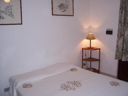 a white bedroom with a bed and a lamp at Villa Tessitore in LMP