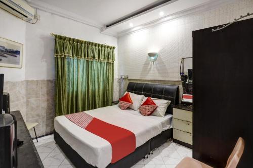 a bedroom with a bed and a dresser and a mirror at Hotel O Manisee 1 Homestay Syariah in Tanjunguma