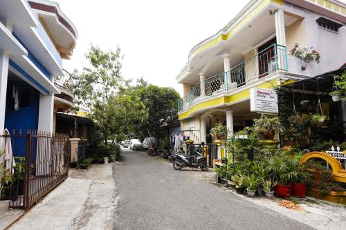a street with a building with a motorcycle parked next to it at Hotel O Manisee 1 Homestay Syariah in Tanjunguma