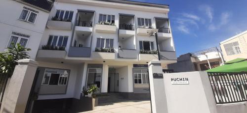 a white building with balconies on the side of it at OYO 1161 Puchin Hotel And Apartment in Da Lat