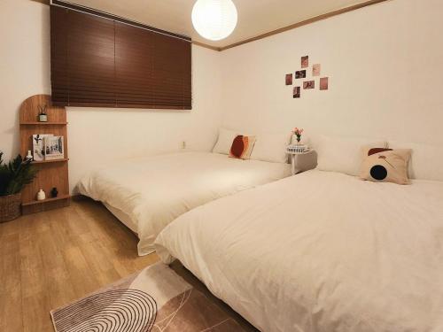 Un dormitorio con dos camas y una ventana. en Nana stay , family trip, KT wiz, haenggung, suwon trip, ajou hospital, en Suwon