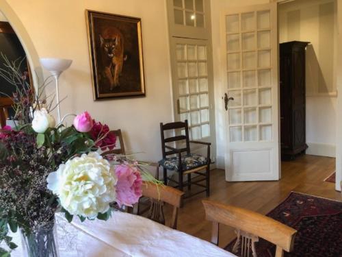 un salon avec une table avec des fleurs dessus dans l'établissement Appartement de caractère au cœur de Poitiers, à Poitiers
