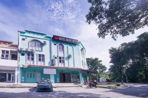 a blue building with a car parked in front of it at Hotel O Night Queen salak Tinggi in Sepang