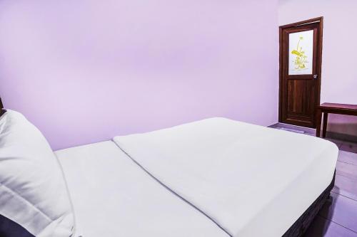 a white bed in a room with a mirror at Hotel O Night Queen salak Tinggi in Sepang