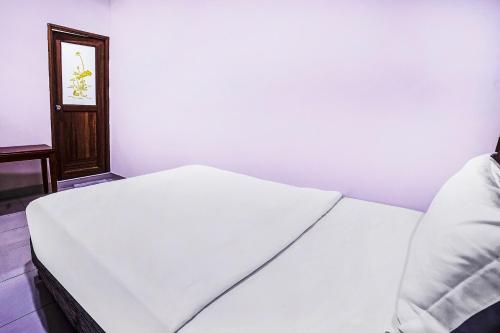 a bedroom with a white bed and a mirror at Hotel O Night Queen salak Tinggi in Sepang