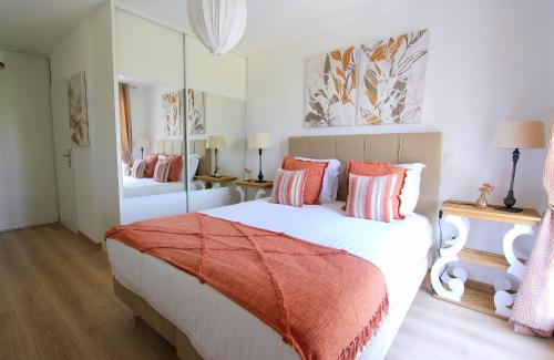 - une chambre dotée d'un grand lit blanc avec des oreillers orange et rose dans l'établissement Cristal6 - Welcoming accomodation up to 6ppl, à Serris