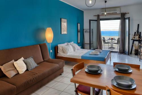 a living room with a couch and a bed and a table at Beachfront Blue Comfort Sitia By ComfortBnb in Sitia