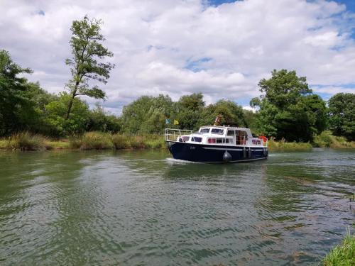 a boat in the water on a river at Gite le Martin Pêcheur au bord du Canal de l'Est in Champneuville
