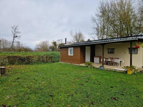 a small house with a grass yard in front of it at Gite le Martin Pêcheur au bord du Canal de l'Est in Champneuville