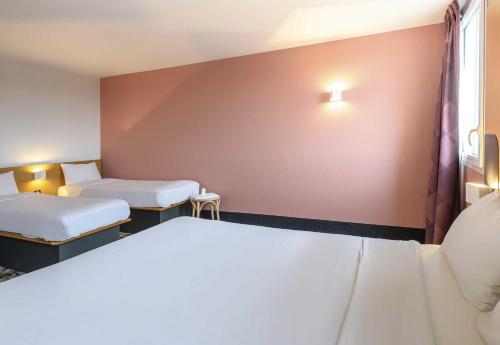 a hotel room with two beds and a window at B&B HOTEL Toulouse Purpan Zénith in Toulouse
