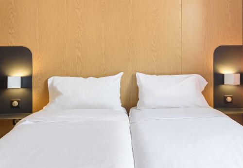 two beds sitting next to each other in a room at B&B HOTEL Toulouse Purpan Zénith in Toulouse