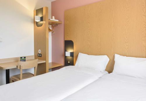 a hotel room with two beds and a desk at B&B HOTEL Toulouse Purpan Zénith in Toulouse
