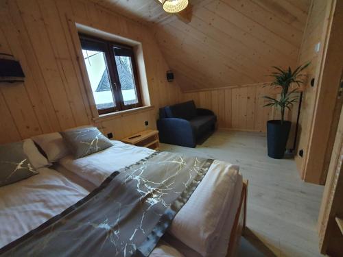 a bedroom with a bed and a couch in a room at Osada Bajka in Murzasichle