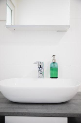 a white sink in a bathroom with a mirror at Superbe appartement 3,5 pièces, parking gratuit in Farvagny-le-Grand