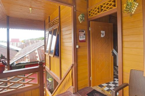 an entrance to a house with a wooden door at Hotel O Pulisan Ekowisata Homestay Near Wisata Pantai Desa Pulisan (Pulisan Beach Tour) in Manado