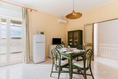 a dining room with a table and chairs and a refrigerator at Casa Vacanze Irene - Salento Selection in Torre Lapillo