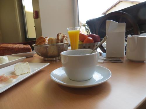 a table with a cup of coffee and a plate of food at Auberge Bressane de Buellas in Buellas
