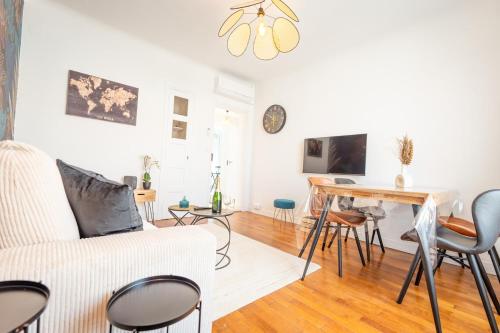 un salon avec un canapé blanc et une table dans l'établissement Appartement Stylé pour 4, à Châlons-en-Champagne