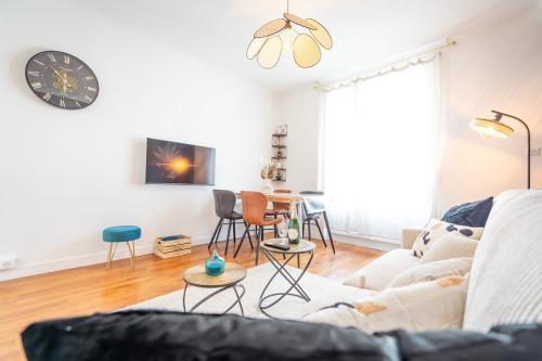 un salon avec un canapé et une horloge au mur dans l'établissement Appartement Stylé pour 4, à Châlons-en-Champagne