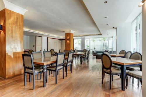 a dining room with wooden tables and chairs at Collection O Legian Near Pantai Kuta Formerly Premium Legian in Legian