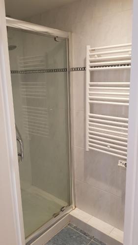 une douche avec une porte vitrée dans une salle de bain dans l'établissement Charmant 73m carré -piscine-500 m de la mer-parking, à Saint-Raphaël