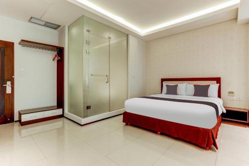 a bedroom with a large bed and a walk in shower at Collection O Legian Near Pantai Kuta Formerly Premium Legian in Legian