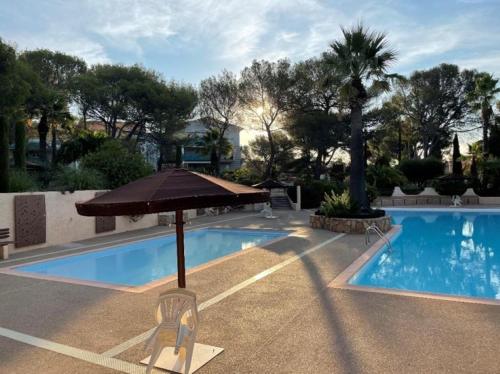 un parasol et une chaise à côté de la piscine dans l'établissement Charmant 73m carré -piscine-500 m de la mer-parking, à Saint-Raphaël