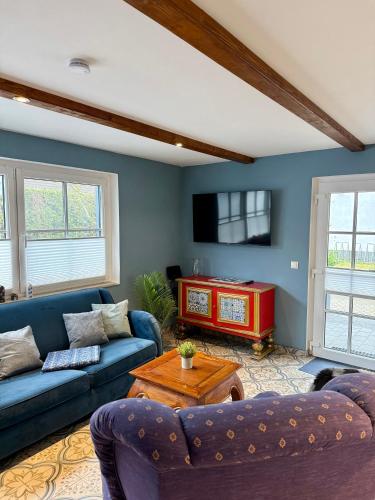 a living room with two couches and a table at Dat Smucke Reethus Erdgeschoss in Born