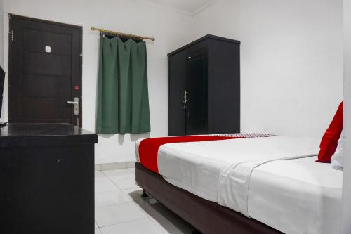 a bedroom with a bed and a green curtain at Hotel O Royani Residence in Jakarta